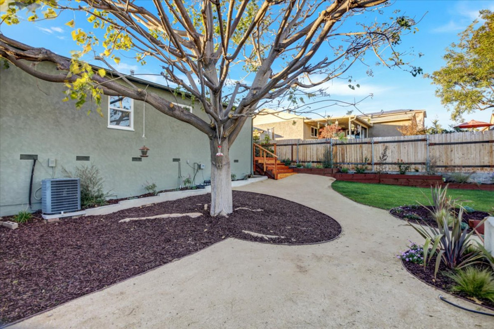 This is an example of a mid-sized modern backyard full sun xeriscape in San Diego with with raised garden bed, decomposed granite and a wood fence.