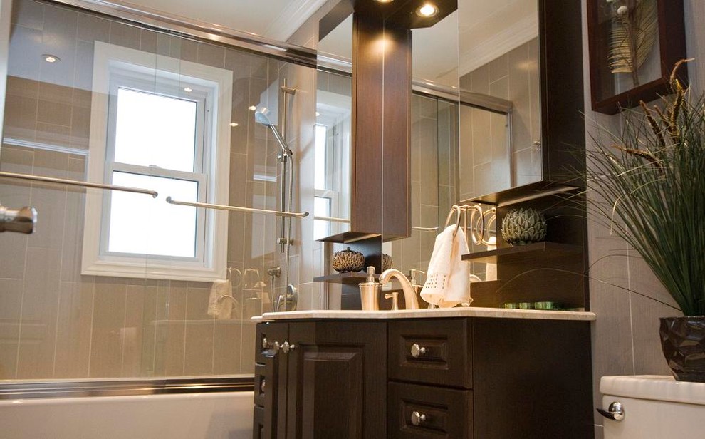 Mid-sized traditional master bathroom in Montreal with recessed-panel cabinets, dark wood cabinets, an alcove tub, an alcove shower, a one-piece toilet, gray tile, porcelain tile, grey walls, ceramic floors, an undermount sink, soapstone benchtops and a sliding shower screen.