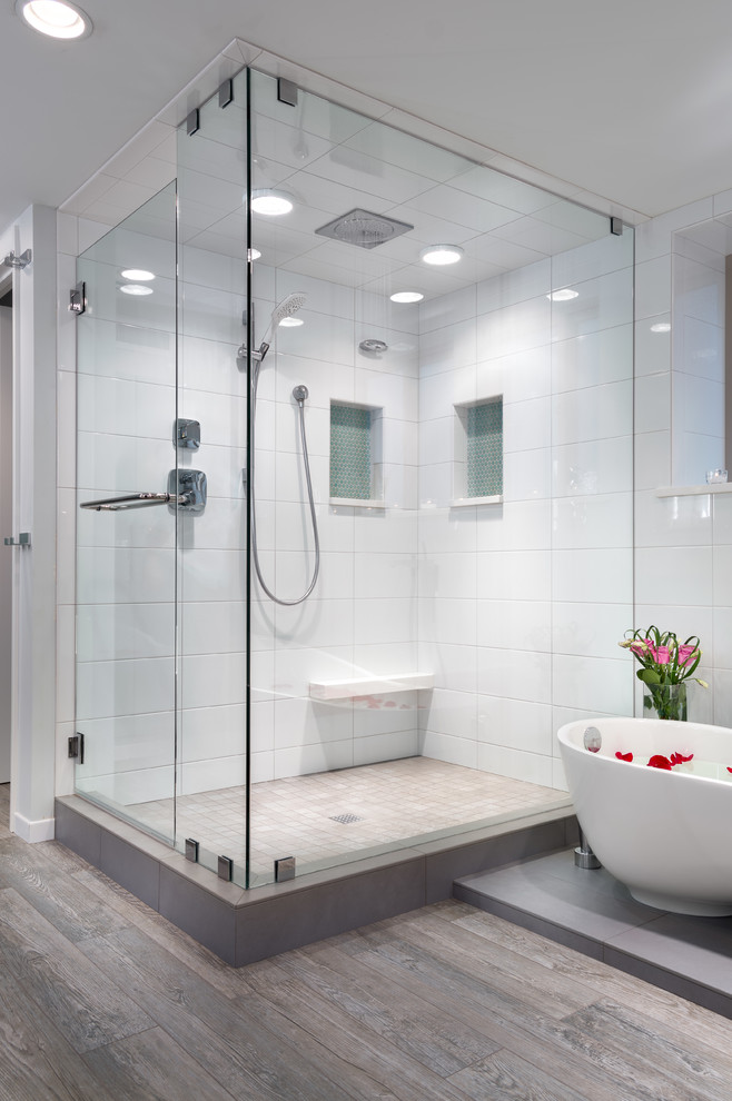 Design ideas for a large modern master bathroom in Portland with an undermount sink, flat-panel cabinets, white cabinets, engineered quartz benchtops, a freestanding tub, a one-piece toilet, white tile, ceramic tile, grey walls and porcelain floors.