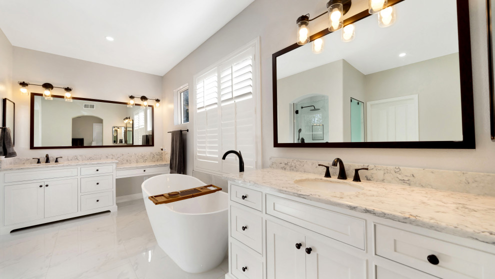 Inspiration for a large retro ensuite bathroom in Los Angeles with white cabinets, a freestanding bath, an alcove shower, beige walls, a hinged door, a single sink, a freestanding vanity unit, porcelain flooring and marble worktops.