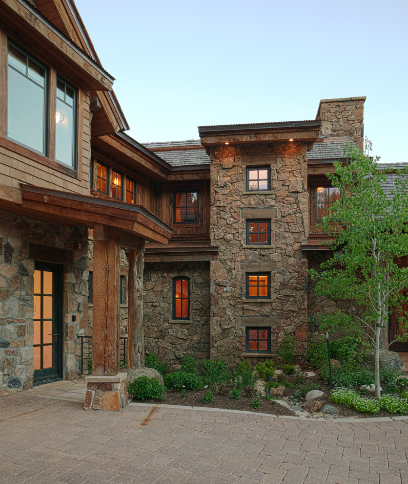 Inspiration for a huge rustic two-story mixed siding house exterior remodel in Denver with a mixed material roof