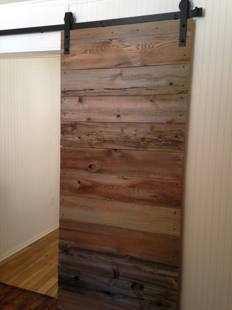 Inspiration for a mid-sized rustic l-shaped medium tone wood floor open concept kitchen remodel with a farmhouse sink, beaded inset cabinets, light wood cabinets, solid surface countertops, beige backsplash, glass tile backsplash, stainless steel appliances and an island
