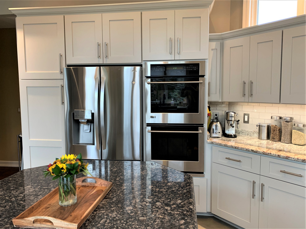 Inredning av ett klassiskt stort flerfärgad flerfärgat kök, med en rustik diskho, luckor med infälld panel, grå skåp, granitbänkskiva, grått stänkskydd, stänkskydd i keramik, rostfria vitvaror, klinkergolv i porslin, en köksö och grått golv