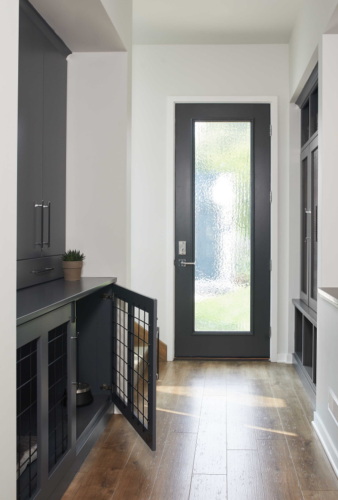 Design ideas for a mid-sized contemporary mudroom in Grand Rapids with white walls, a single front door, brown floor, medium hardwood floors and a glass front door.