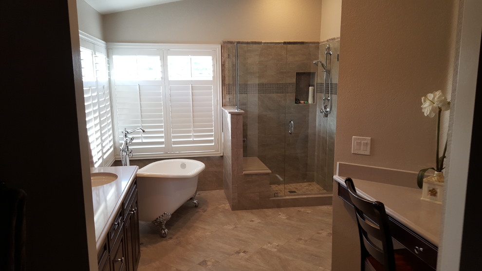 This is an example of a mid-sized traditional master bathroom in Orange County with raised-panel cabinets, dark wood cabinets, a claw-foot tub, a corner shower, a two-piece toilet, gray tile, porcelain tile, beige walls, porcelain floors, an undermount sink, engineered quartz benchtops, beige floor, a hinged shower door and white benchtops.