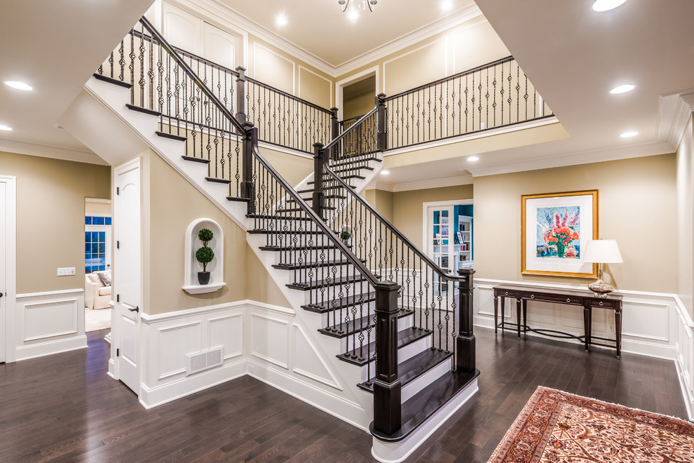 This is an example of a large transitional foyer in Other with beige walls and dark hardwood floors.