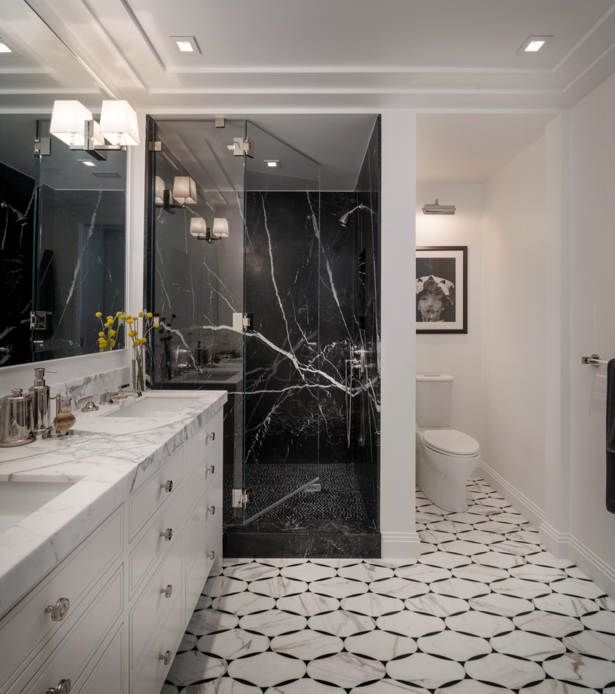 This is an example of a transitional bathroom in San Francisco with an undermount sink, flat-panel cabinets, white cabinets, an alcove shower, a two-piece toilet, black tile, stone slab and white walls.
