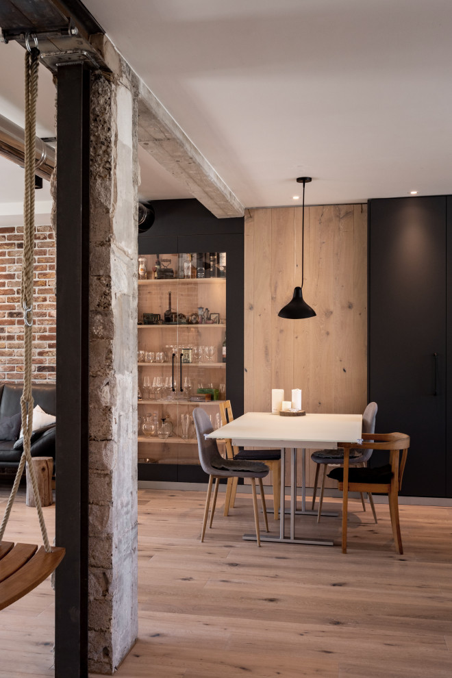 Стильный дизайн: кухня-столовая среднего размера в стиле лофт с черными стенами, паркетным полом среднего тона, синим полом и кирпичными стенами - последний тренд