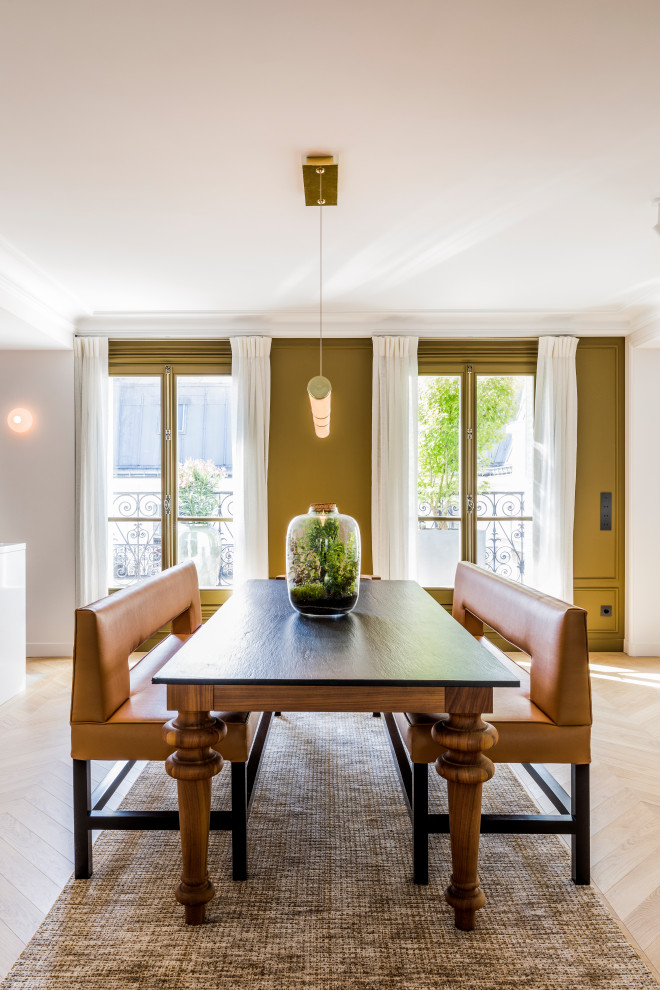 Immagine di una sala da pranzo aperta verso il soggiorno classica di medie dimensioni con pareti verdi, parquet chiaro, nessun camino, pavimento beige e boiserie