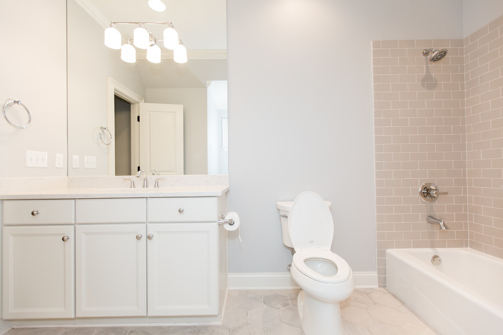 Design ideas for a small contemporary 3/4 bathroom in Birmingham with recessed-panel cabinets, white cabinets, an alcove tub, a shower/bathtub combo, a two-piece toilet, beige tile, pink tile, ceramic tile, white walls, ceramic floors, an undermount sink, solid surface benchtops, beige floor, a shower curtain and white benchtops.