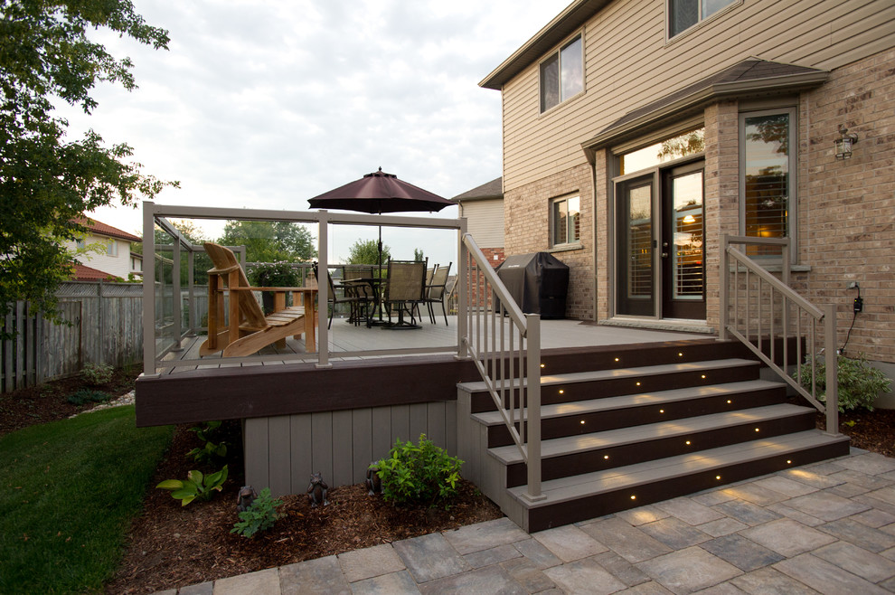 Design ideas for a large contemporary backyard deck in Toronto with no cover and with skirting.
