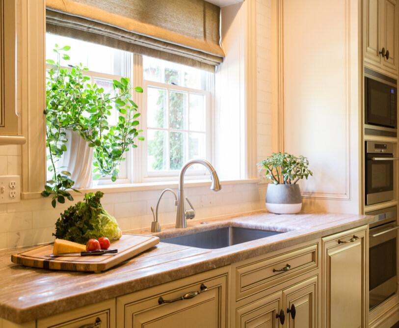 Immagine di una cucina abitabile design di medie dimensioni con ante beige, elettrodomestici in acciaio inossidabile e lavello da incasso