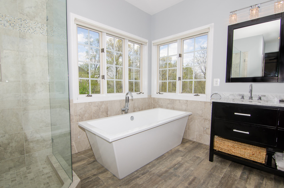 Mid-sized transitional master bathroom in DC Metro with an undermount sink, shaker cabinets, dark wood cabinets, granite benchtops, a freestanding tub, a corner shower, a two-piece toilet, beige tile, ceramic tile, blue walls, porcelain floors, brown floor and a hinged shower door.