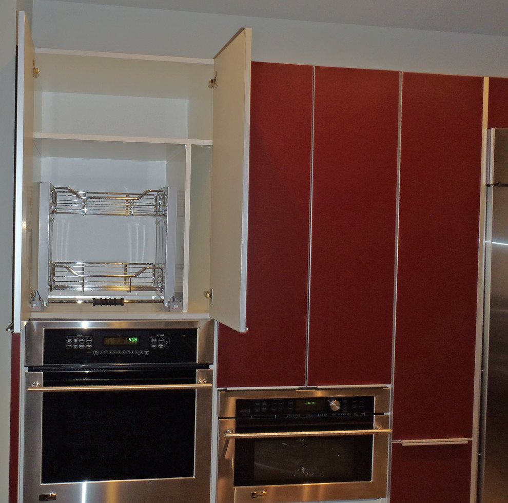 Photo of a mid-sized contemporary eat-in kitchen in Hawaii with an undermount sink, flat-panel cabinets, red cabinets, granite benchtops, metallic splashback, porcelain splashback, stainless steel appliances and porcelain floors.