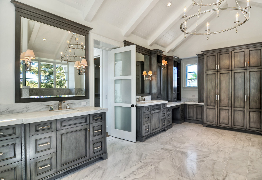 This is an example of a transitional master bathroom in Orange County with an undermount sink, dark wood cabinets and white walls.