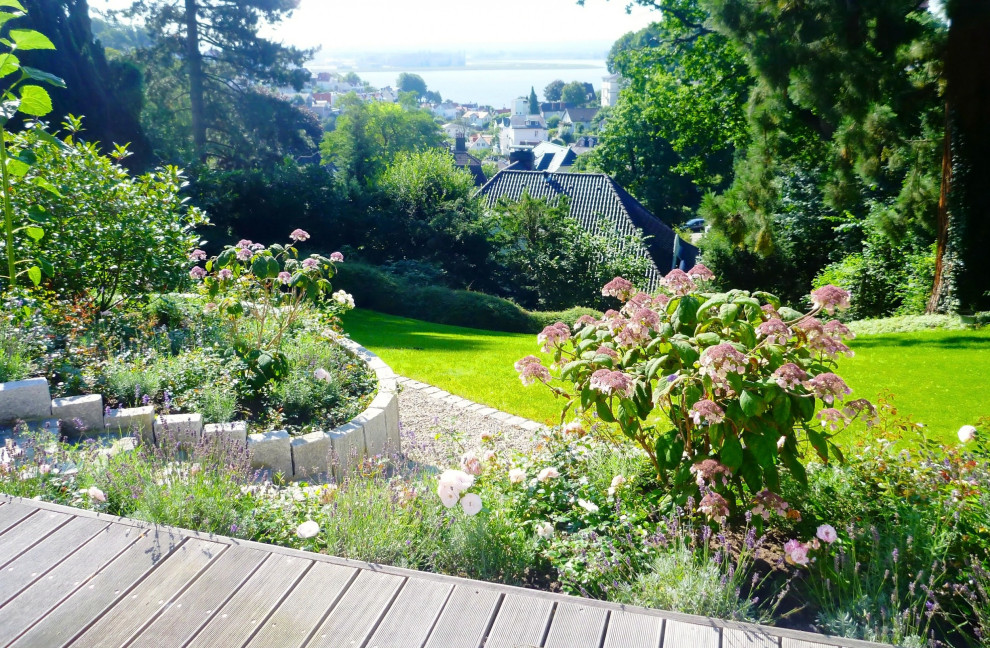 Geräumige Moderne Gartenmauer im Frühling mit Natursteinplatten in Hamburg