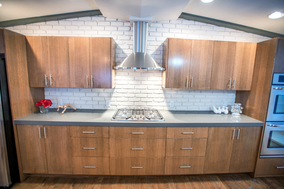 Photo of a midcentury single-wall eat-in kitchen in Salt Lake City with an undermount sink, flat-panel cabinets, brown cabinets, quartz benchtops, beige splashback and stainless steel appliances.