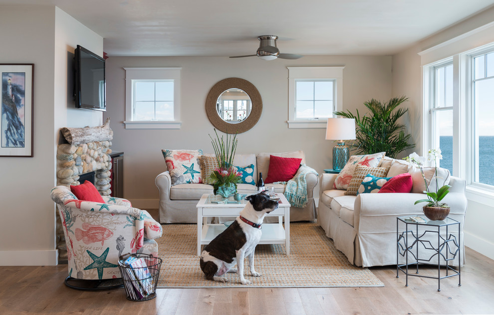 Inspiration for a mid-sized beach style open concept family room in Providence with beige walls, light hardwood floors, a standard fireplace, a stone fireplace surround and a wall-mounted tv.