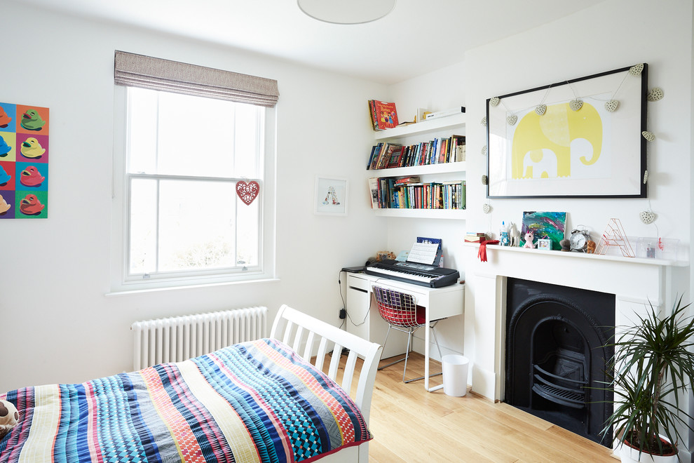 Contemporary gender-neutral kids' room in London with white walls, light hardwood floors and beige floor.