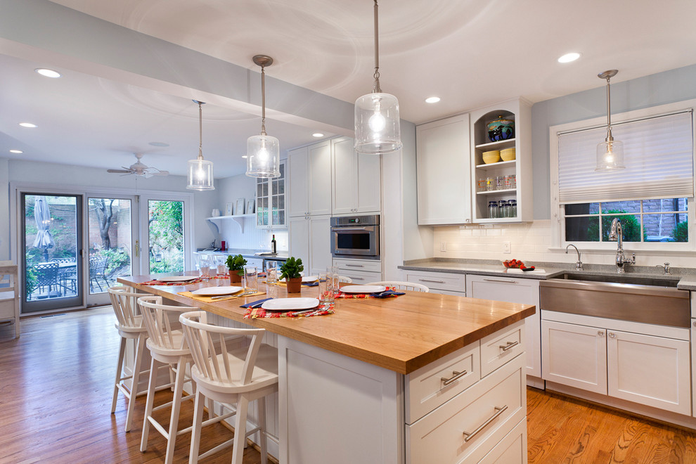 Design ideas for a traditional kitchen in DC Metro with a farmhouse sink, stainless steel appliances and wood benchtops.