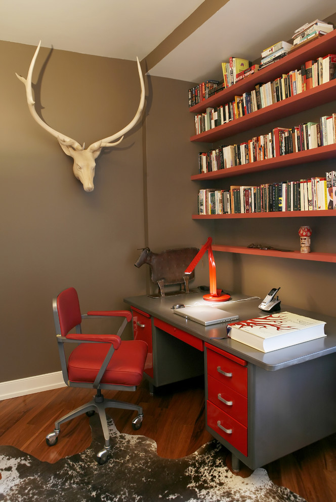 Small contemporary home office in New York with brown walls, medium hardwood floors and a freestanding desk.