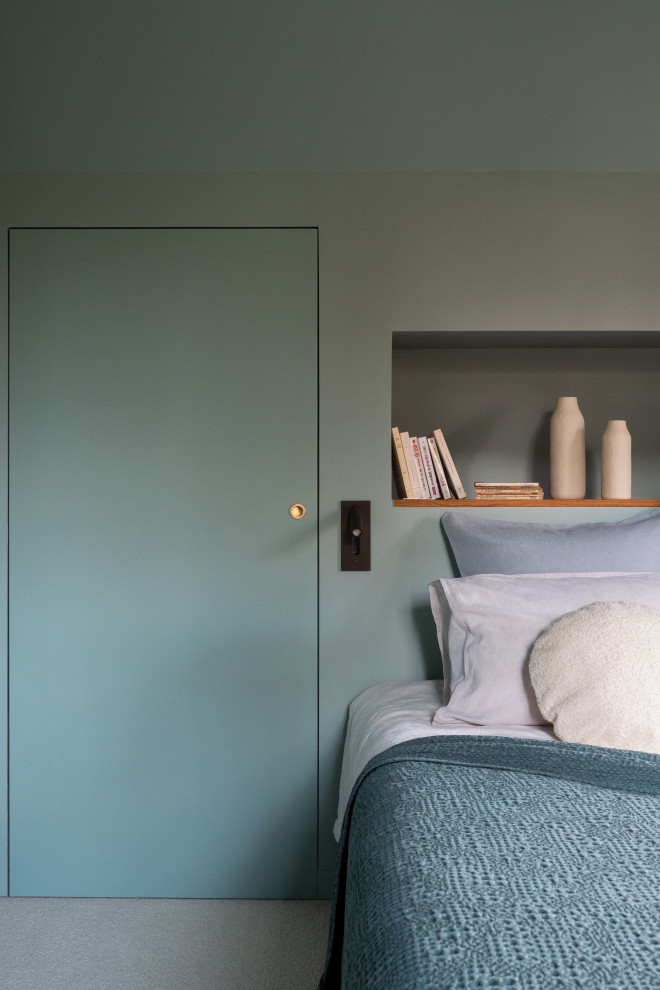 На фото: большая хозяйская спальня в стиле модернизм с зелеными стенами и ковровым покрытием без камина с