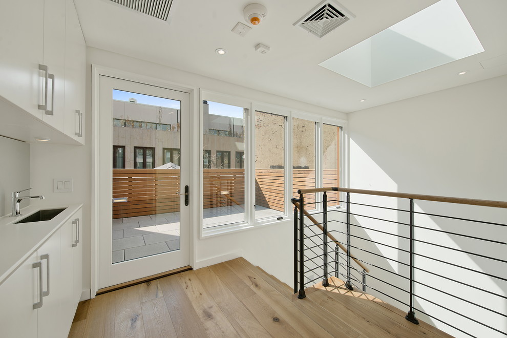 Contemporary hallway in New York with white walls and medium hardwood floors.