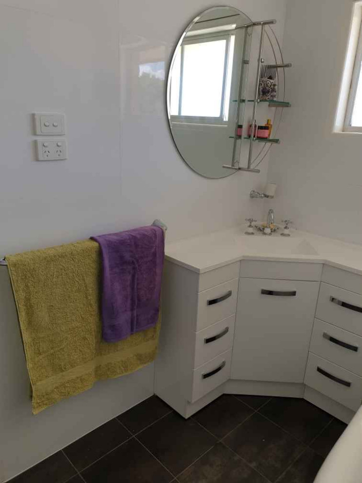 Photo of a small transitional 3/4 bathroom in Brisbane with white cabinets, a claw-foot tub, white tile, ceramic tile, white walls, porcelain floors, an integrated sink, solid surface benchtops, multi-coloured floor, a sliding shower screen, white benchtops, a single vanity and a freestanding vanity.