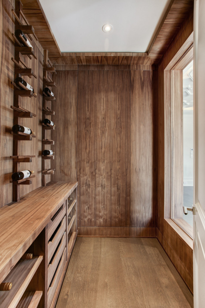 Photo of a contemporary wine cellar in Toronto with medium hardwood floors, display racks and brown floor.