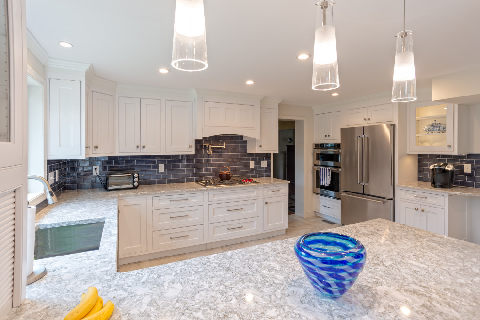 Design ideas for a large transitional u-shaped eat-in kitchen in Philadelphia with a drop-in sink, shaker cabinets, white cabinets, quartz benchtops, blue splashback, porcelain splashback, stainless steel appliances, porcelain floors, a peninsula, grey floor and white benchtop.