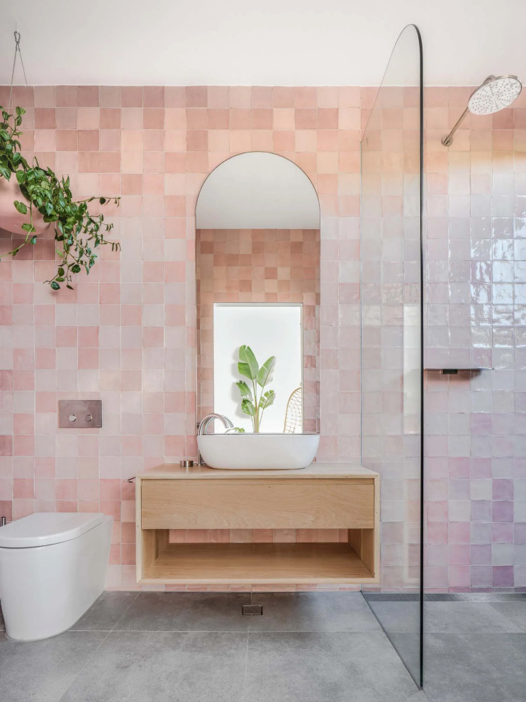 Idéer för att renovera ett funkis beige beige badrum, med släta luckor, skåp i ljust trä, en kantlös dusch, rosa kakel, ett fristående handfat, grått golv och med dusch som är öppen