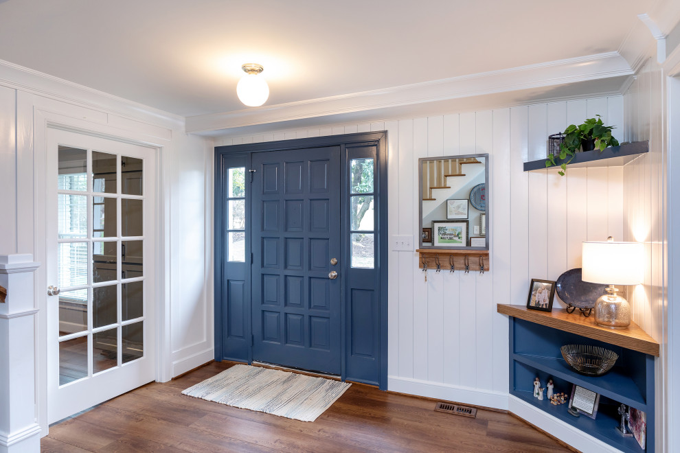 На фото: прихожая в стиле неоклассика (современная классика) с белыми стенами, полом из винила, одностворчатой входной дверью, синей входной дверью, коричневым полом и стенами из вагонки с
