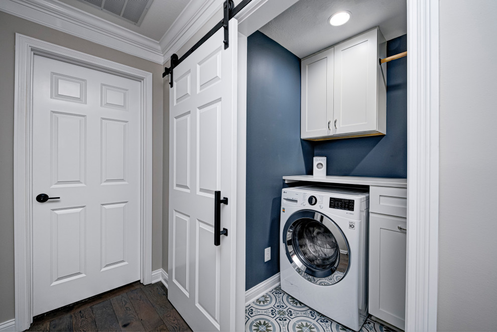 Inspiration for a contemporary dedicated laundry room in Indianapolis with shaker cabinets, white cabinets, blue walls, ceramic floors, white benchtop, a side-by-side washer and dryer and multi-coloured floor.