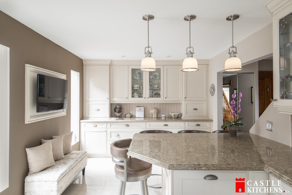 Inspiration for a mid-sized transitional galley porcelain tile enclosed kitchen remodel in Toronto with an undermount sink, shaker cabinets, beige cabinets, quartzite countertops, beige backsplash, stainless steel appliances and an island