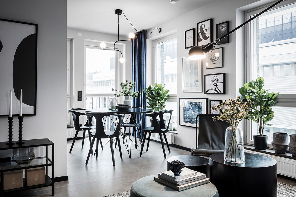 Large scandinavian open plan dining in Gothenburg with white walls, light hardwood floors, no fireplace and grey floor.