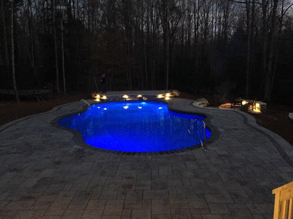 Example of a large transitional backyard concrete paver and custom-shaped natural pool landscaping design in Raleigh
