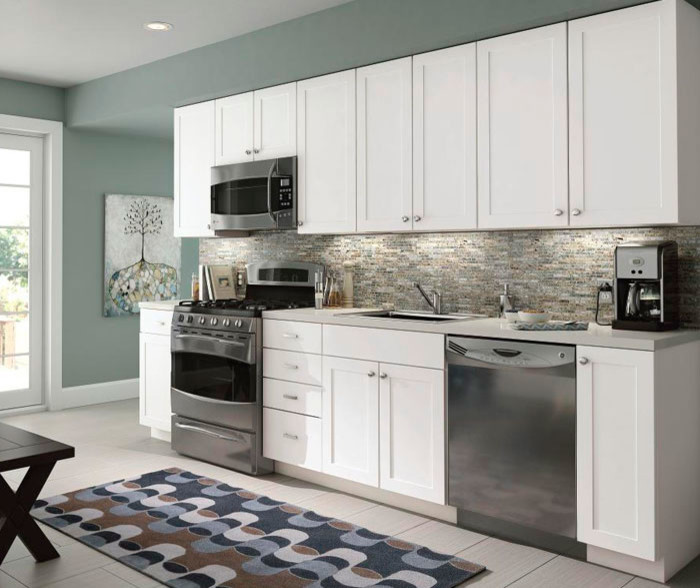 Example of a small transitional single-wall vinyl floor enclosed kitchen design with a drop-in sink, shaker cabinets, white cabinets, granite countertops, metallic backsplash, matchstick tile backsplash, stainless steel appliances and an island