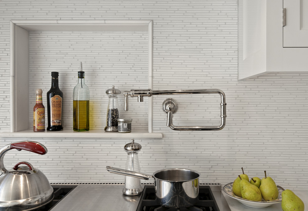 Photo of a traditional eat-in kitchen in New York with a farmhouse sink, shaker cabinets, white cabinets, marble benchtops, white splashback and stainless steel appliances.