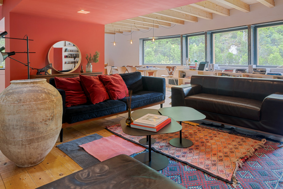 Idéer för stora funkis loftrum, med ett bibliotek, röda väggar, mellanmörkt trägolv, en standard öppen spis, en spiselkrans i gips och brunt golv