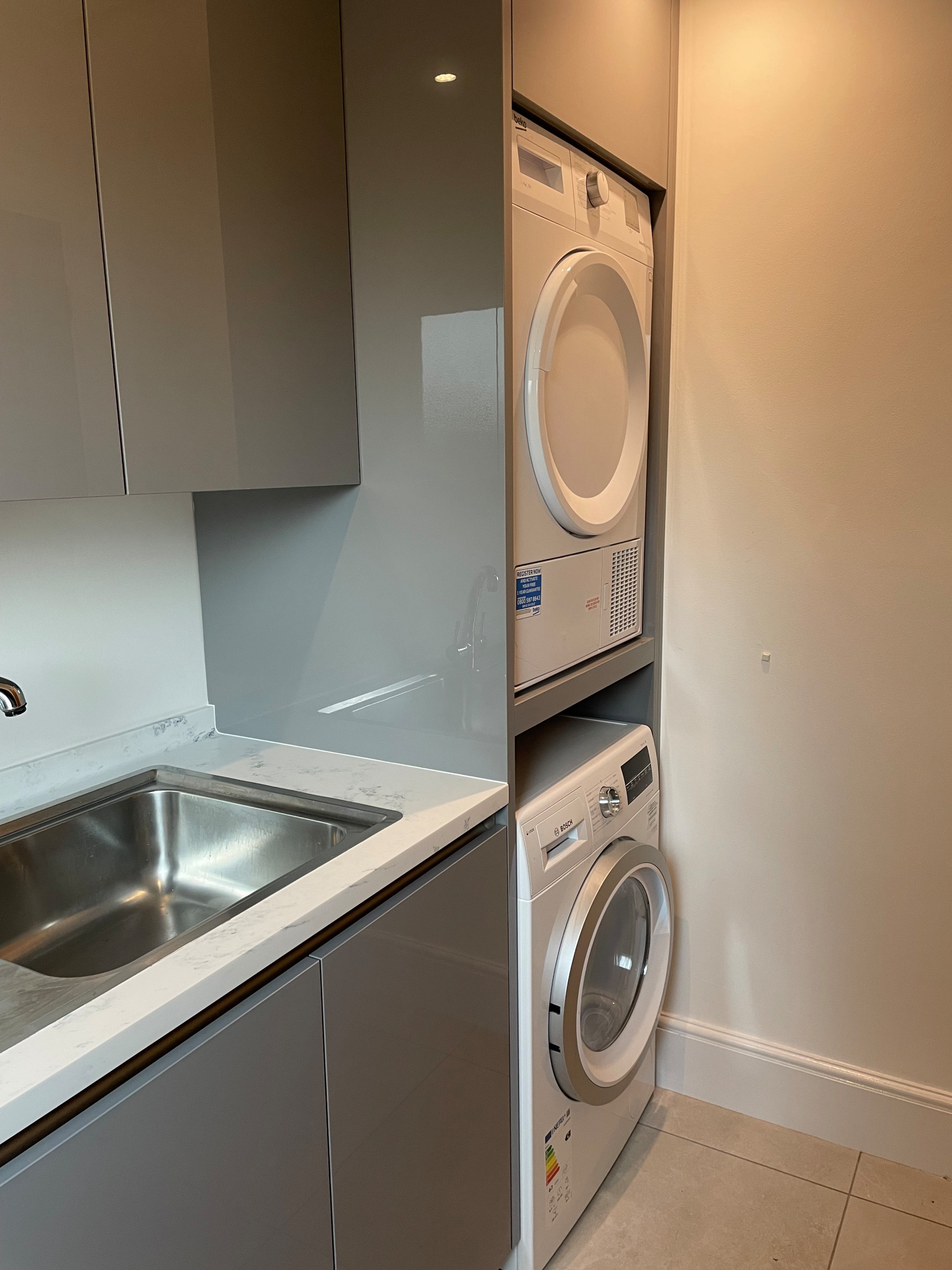 High Gloss Gravel Handleless Kitchen with White and Grey Solid Surface Tops