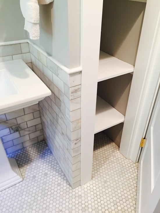 This is an example of a bathroom in Boston with open cabinets, white cabinets, gray tile, stone tile and grey walls.