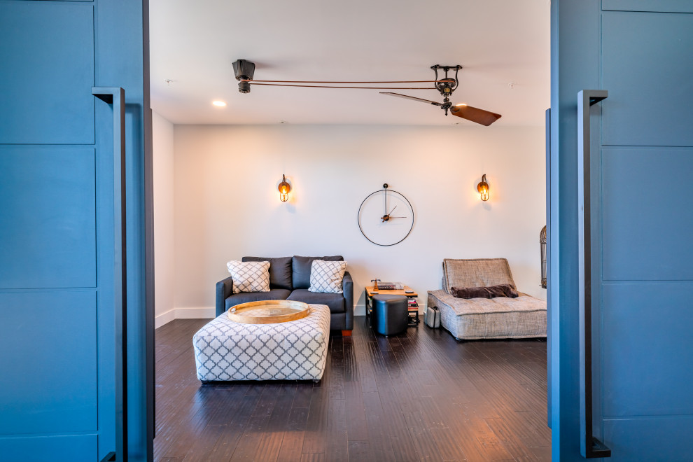 Стильный дизайн: изолированная гостиная комната среднего размера в стиле модернизм с с книжными шкафами и полками, бежевыми стенами, темным паркетным полом и коричневым полом - последний тренд
