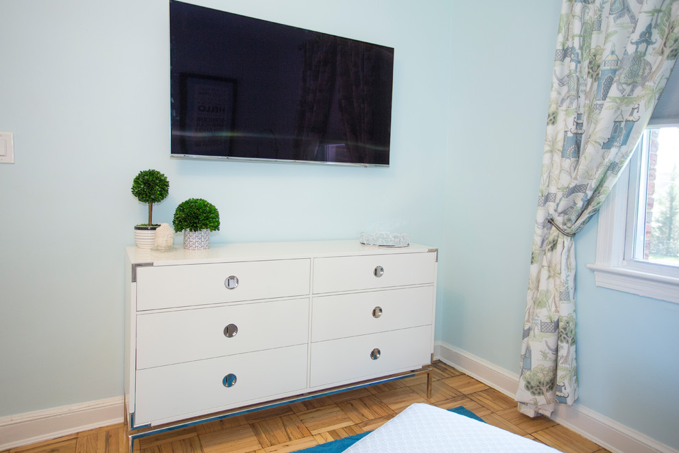 This is an example of a small transitional master bedroom in DC Metro with blue walls and light hardwood floors.