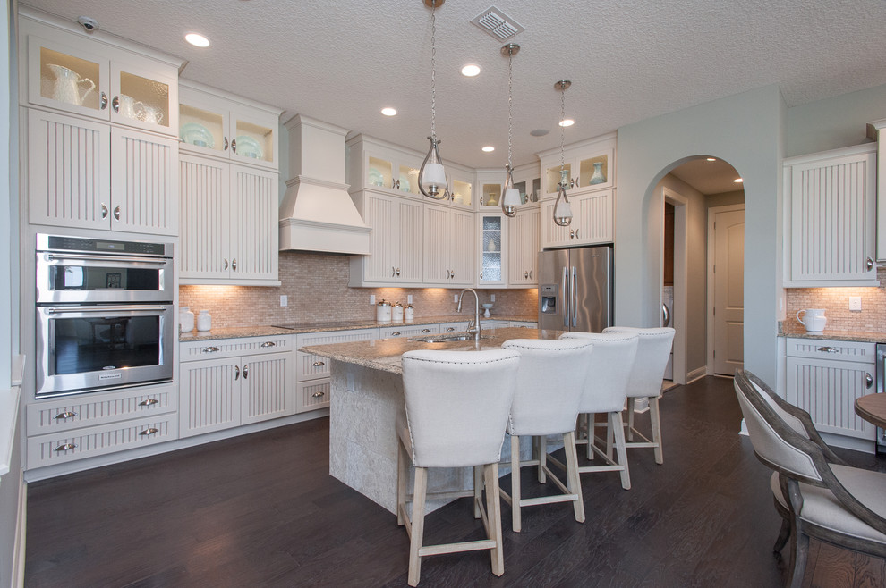 Design ideas for a mid-sized country single-wall eat-in kitchen in Jacksonville with a double-bowl sink, louvered cabinets, white cabinets, marble benchtops, beige splashback, stone tile splashback, stainless steel appliances, vinyl floors and with island.