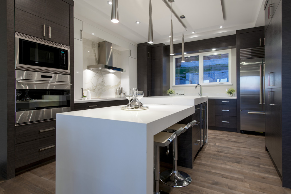 Inspiration for a large modern l-shaped open plan kitchen in Vancouver with flat-panel cabinets, dark wood cabinets, quartz benchtops, white splashback, stainless steel appliances, medium hardwood floors and with island.