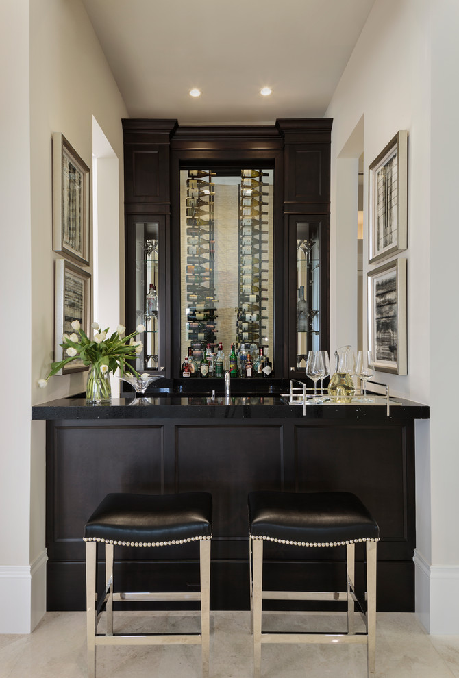 Inspiration for a transitional seated home bar in Miami with glass-front cabinets, black cabinets and beige floor.