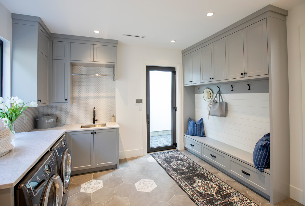 Design ideas for a country l-shaped laundry room in Vancouver with an undermount sink, shaker cabinets, grey cabinets, white walls, a side-by-side washer and dryer, grey floor and white benchtop.