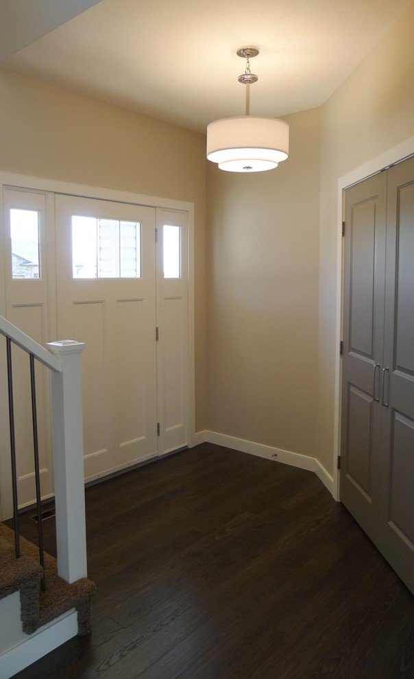 Small transitional dark wood floor front door photo with beige walls and a white front door