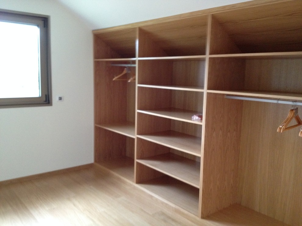 Aménagement de dressing in bois clair With un placard sans porte and parquet clair.
