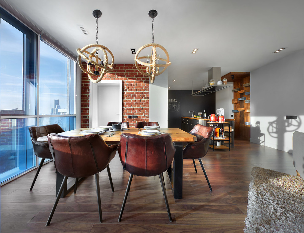 Photo of an industrial open plan dining in Yekaterinburg with white walls, medium hardwood floors and brown floor.